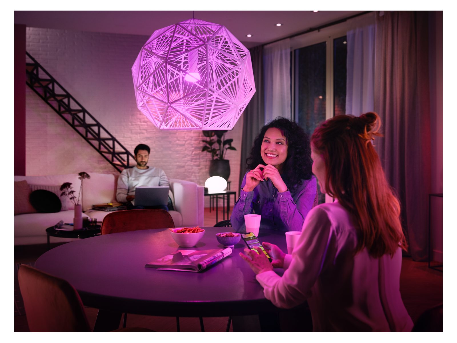 people sitting at a table with a violet coloured light shining over them