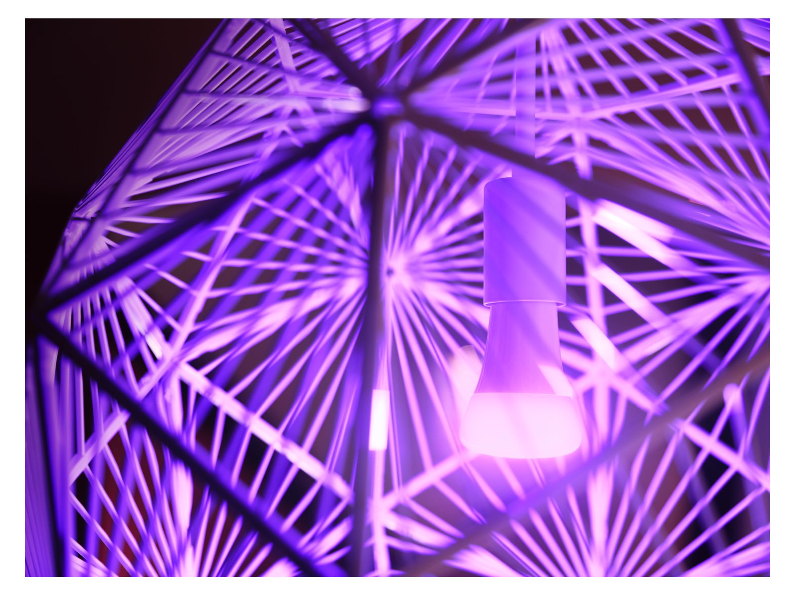 super close up of a lampshade with a bulb emitting a violet light