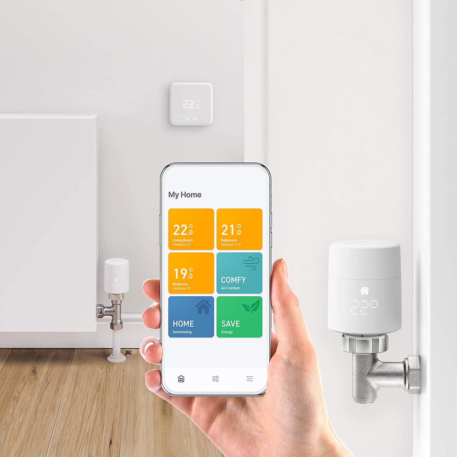 a tado smart thermostatic radiator valve and a mobile phone showing the tado app