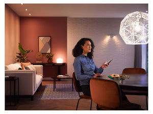 A person sitting at a table in a room filled with various lights showing different shades of white