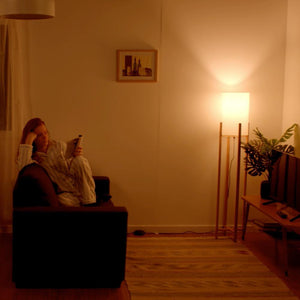 Person on a sofa reading with a warm cream coloured light
