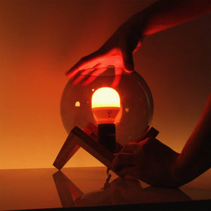 a person holding a warm amber light coming from a lamp 