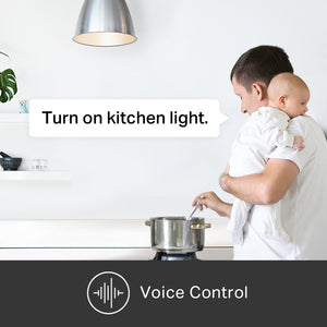 man holding a baby and stirring a pot issuing a voice command, it reads, turn on kitchen light.