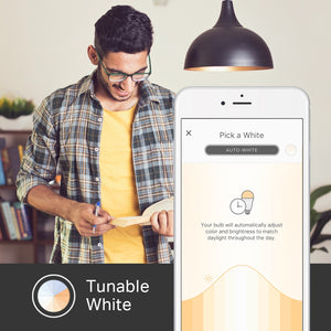 a person reading a book under a light with a mobile phone showing the kasa apps tunable white function