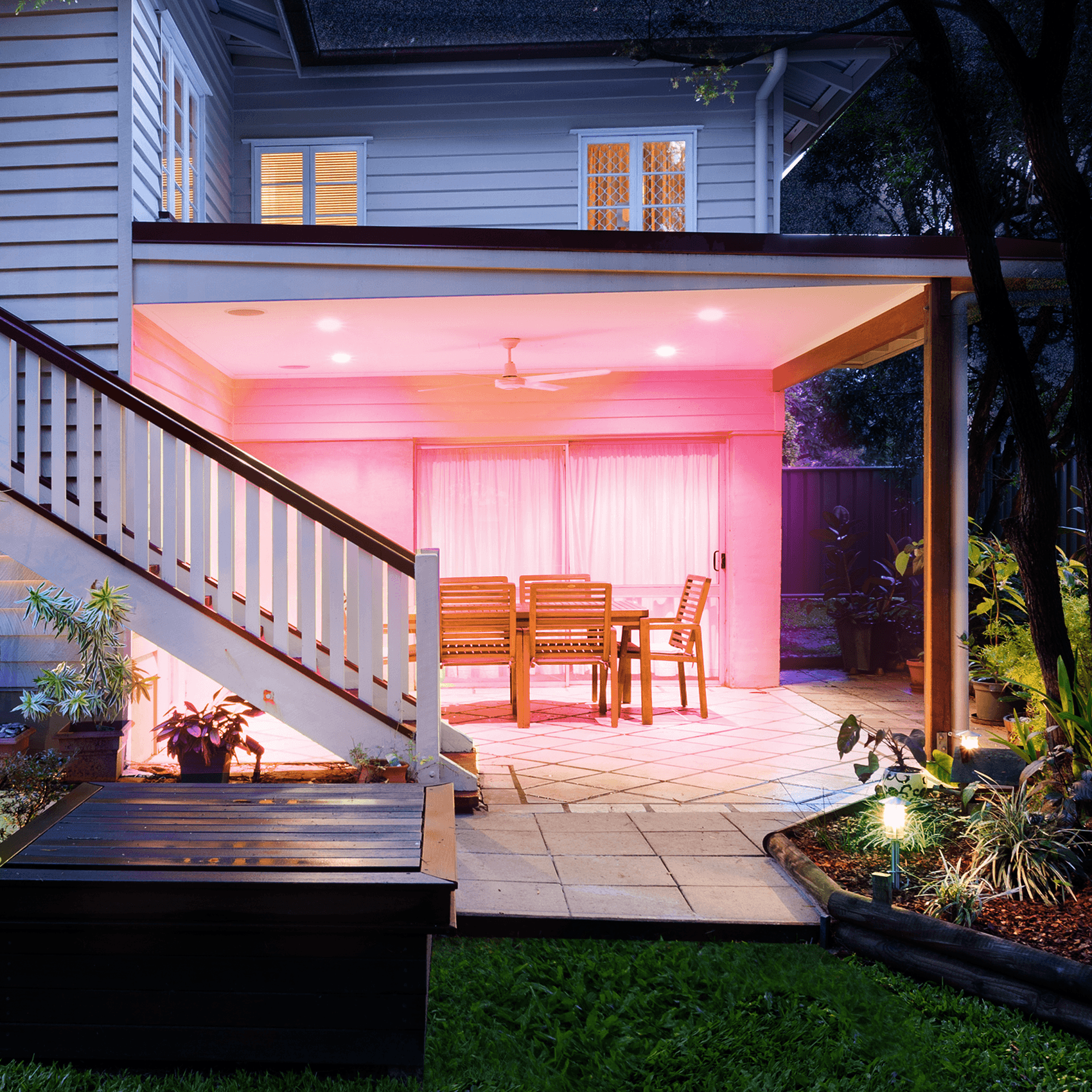 a well lit patio area in a garden next to a house