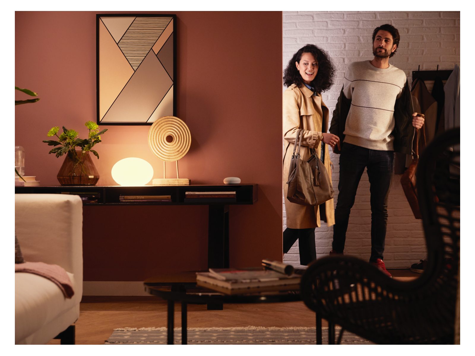 2 people arriving in a living room with warm white lighting