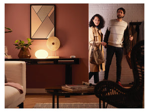 2 people arriving in a living room with warm white lighting