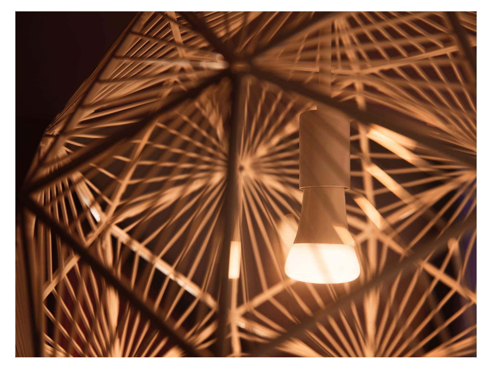 A close up of a philips hue white light smart bulb in a lamp shade